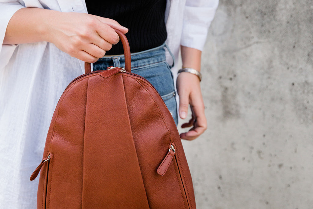 women holding teardrop multi zip backpack