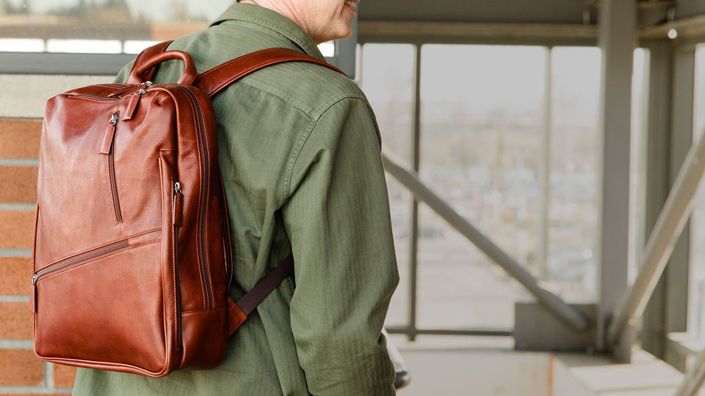 Man with green shirt and brown leather Osgoode Marley backpack