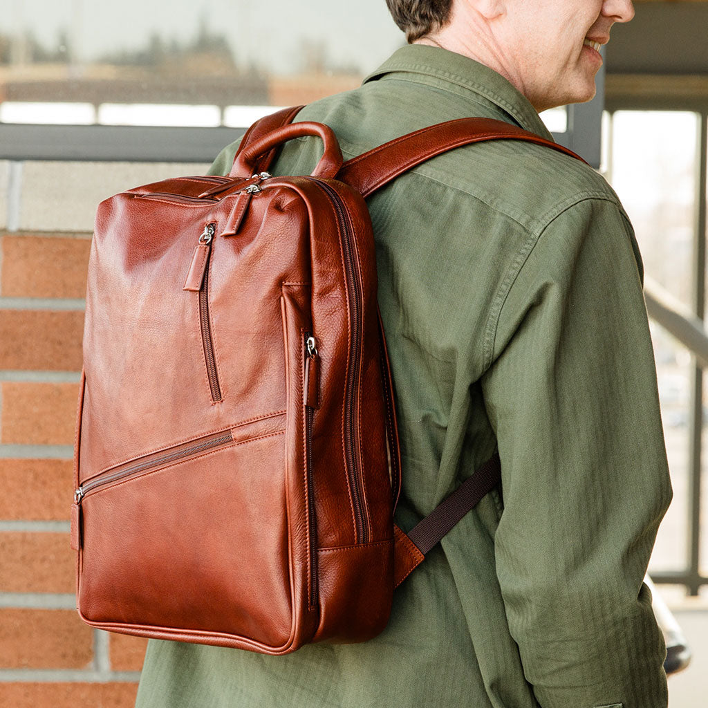 Man with green shirt and brown leather Osgoode Marley backpack